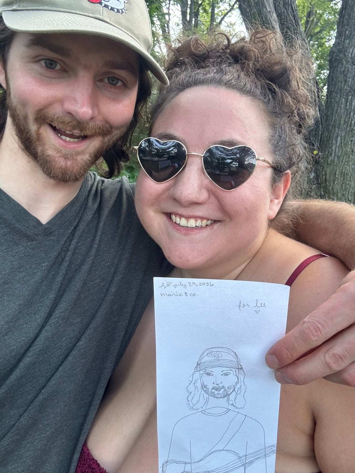 A fan holding up the portrait they drew of Lee at a show